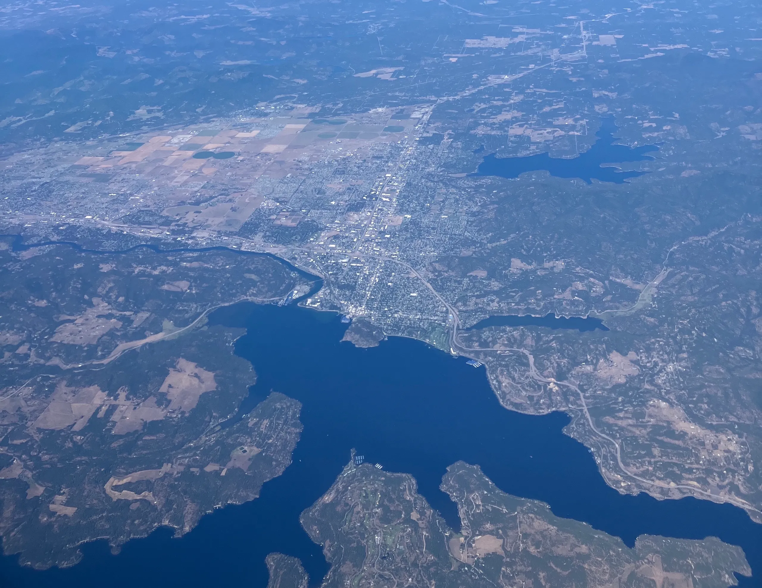 Aerial view of Coeur d’Alene showing downtown, the lakefront resort, and the north end of Lake Coeur d’Alene curving into the mountains.